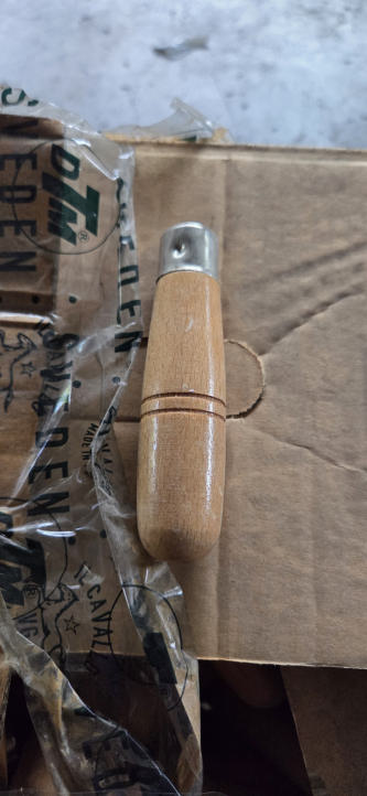Manico in legno con innesto metallico fotografato tra i componenti dello stock